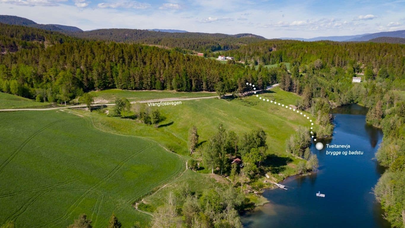 Dronebilde over Tveitanevja - grønt kulturlandskap og blå sideevje til Telemarkskanalen