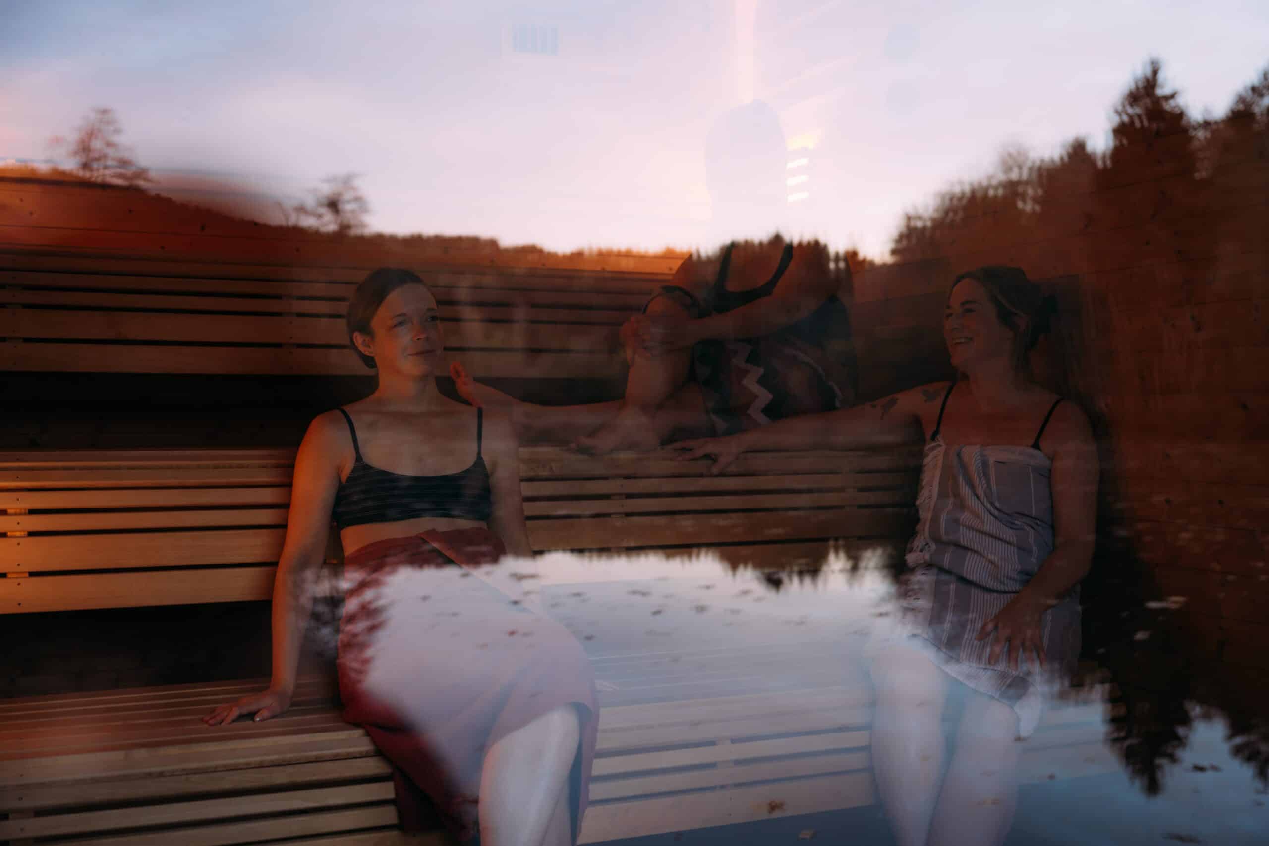 a group of women sitting on a sauna bench