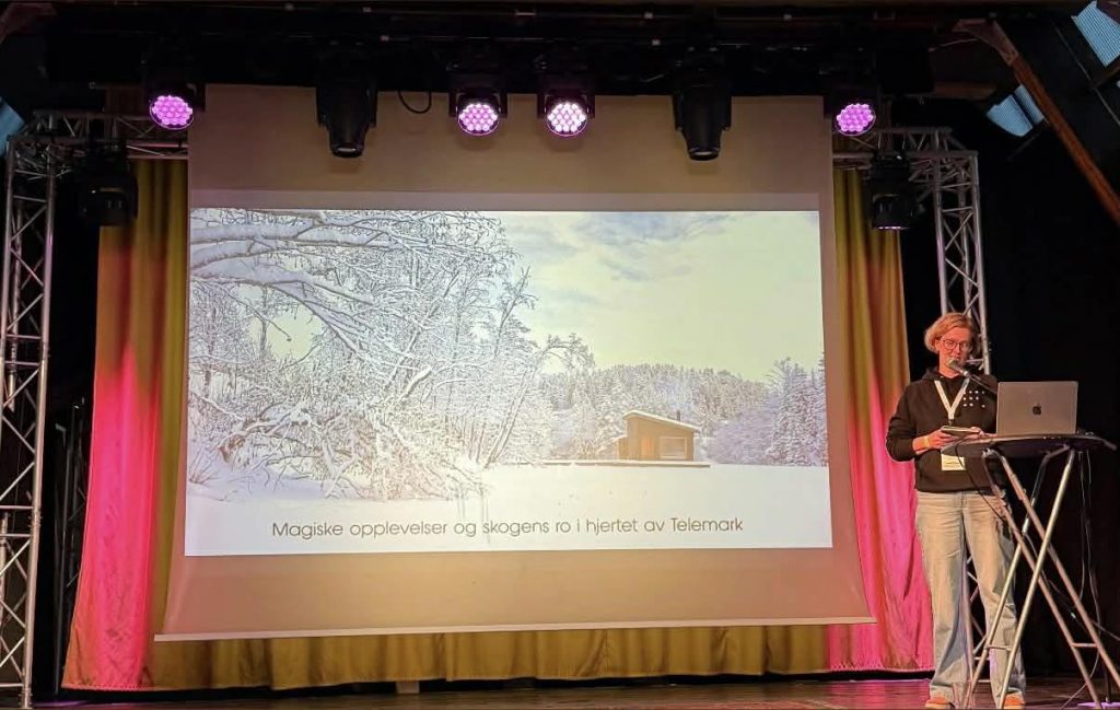 Bodil presenterer Skogens rom sauna på scenen under Badstukonferansen